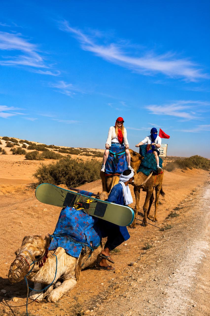A group of people riding camels in the desert.