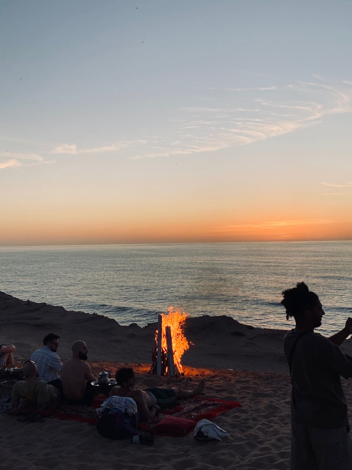 Sunset at Timlaline Dunes at Timlaline dunes near Agadir, Morocco — A group of people enjoying a beach fire.
