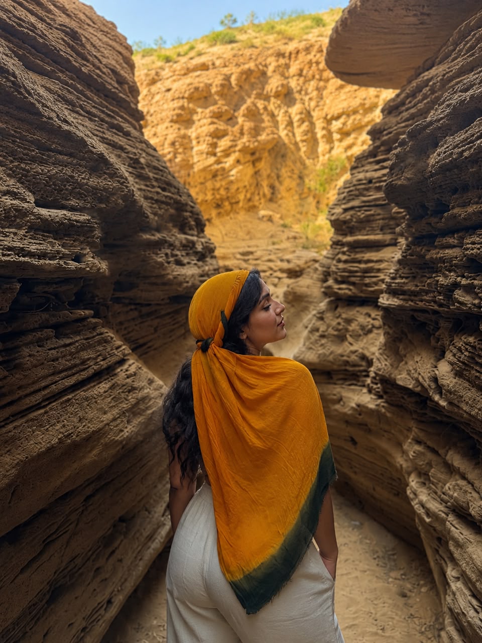 A woman wearing a yellow scarf standing in a cave. — Timlaline / Timlalin dunes quad tour photo, Agadir Morocco